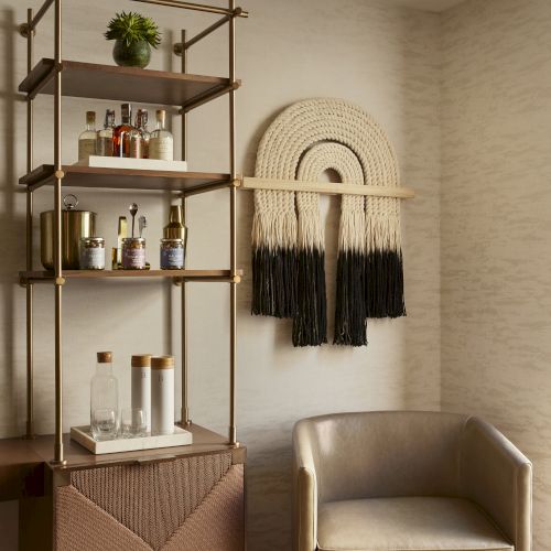 A cozy, boho-style corner with wooden shelves, a hanging rack for bags, a small chair, and soft earthy tones in warm lighting. (End sentence.)