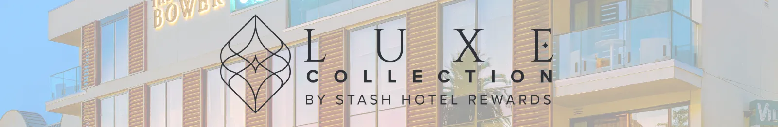 A modern hotel building facade with glass balconies and warm wood accents, featuring a large &ldquo;LUXE COLLECTION by STASH HOTEL REWARDS&rdquo; logo overlay.